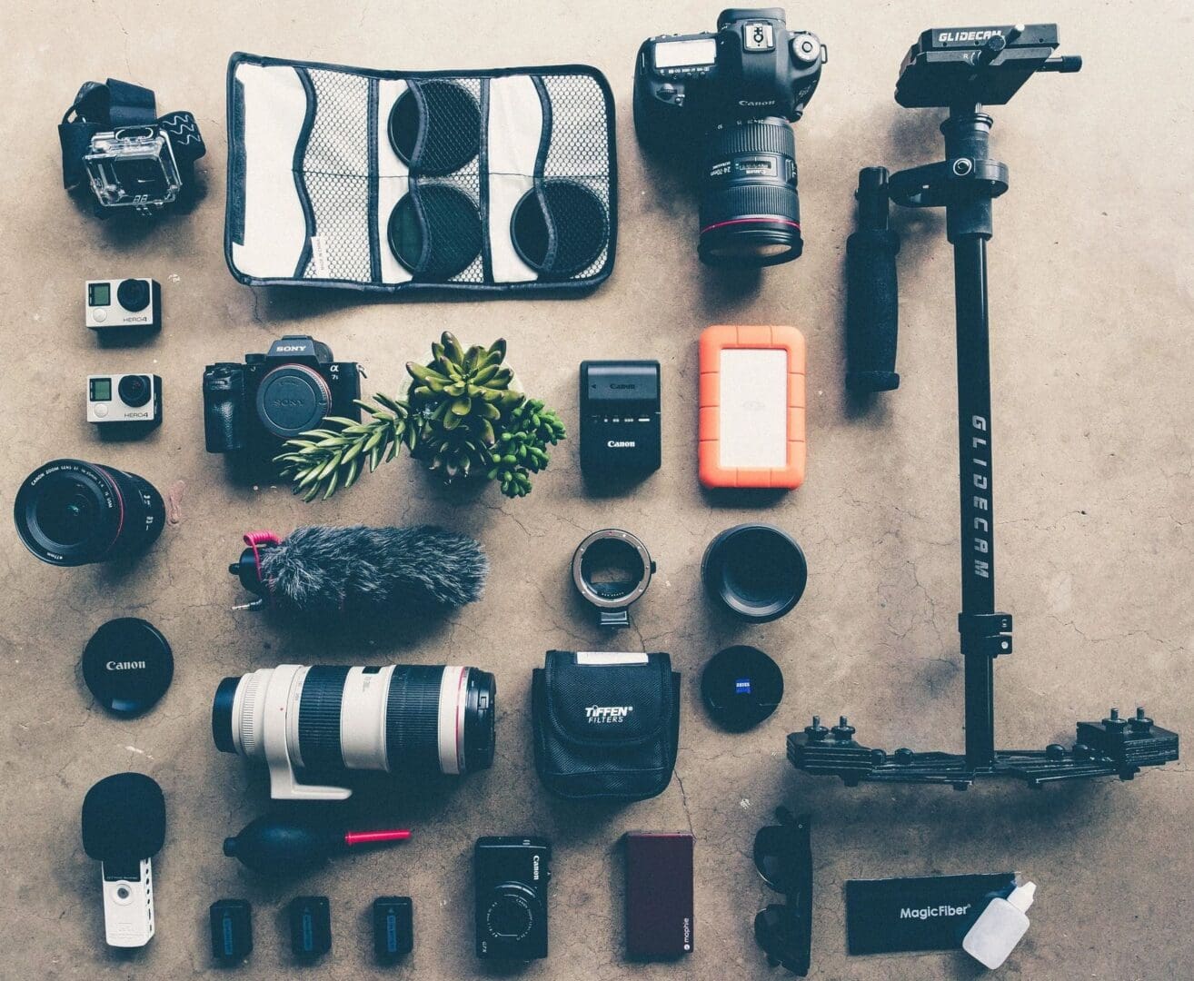 A table with many different types of cameras and equipment.